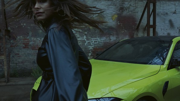 Kvindelig BMW-ejer foran sin BMW M4 Coupe 
